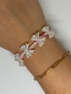 Embrace your coquette style with this handcrafted bracelet, featuring soft pink beads and elegant, pearl-like silver bows. Stylish and feminine, this bracelet is perfect for those who love a delicate, charming accessory that effortlessly enhances their look. Adjustable Feminine Pearl Beaded Bracelets, Adjustable Pink Pearl Bracelet Feminine Style, Pink Adjustable Feminine Pearl Bracelet, Adjustable Feminine Pink Pearl Bracelet, Feminine White Beaded Bracelets, Feminine White Beaded Bracelet, Dainty Pink Beaded Bracelets For Party, Pink Pearl Bracelet For Party, White Feminine Bracelets For Party