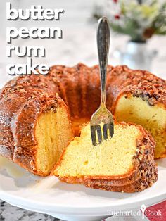 a bundt cake on a plate with a fork sticking out of it and the words, butter pecan rum cake