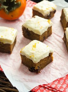 several pieces of cake sitting on top of a piece of paper next to an orange