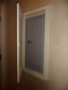 an open door in the corner of a room that is being painted tan and white