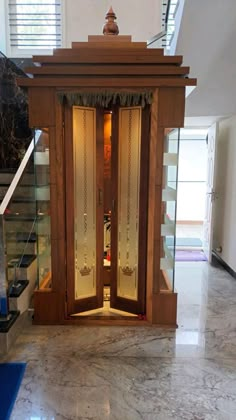 an open wooden door in the middle of a marble floored area with stairs leading up to it