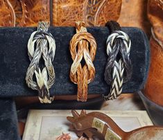 three braided hair clips sitting on top of a black case