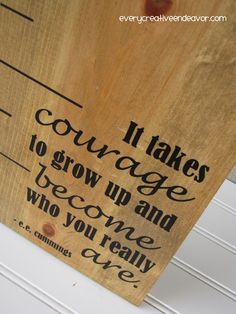 a wooden sign that says it takes courage to grow up and become who you really are