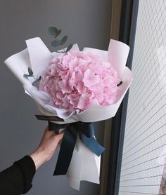 a person holding a bouquet of pink flowers