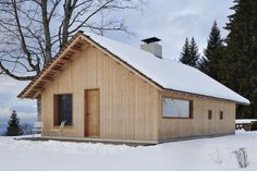 a small wooden cabin sitting in the snow