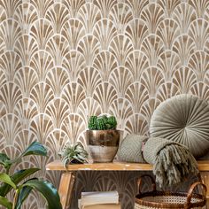 a wooden table topped with a potted plant next to a wallpapered wall