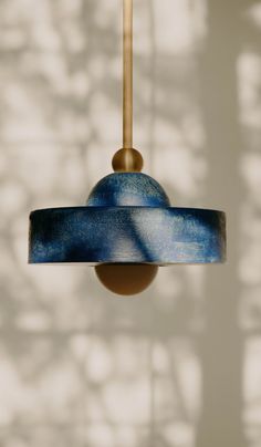 a blue and gold lamp hanging from a ceiling