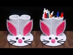 two toilet paper holders with bunny ears and pencils in them