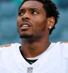 a close up of a person wearing a football uniform with ear buds on his ears