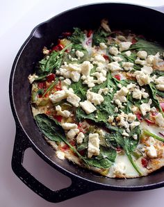 a skillet filled with food sitting on top of a white counter next to a knife