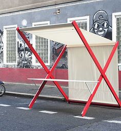 a red and white structure sitting on the side of a road next to a motorcycle