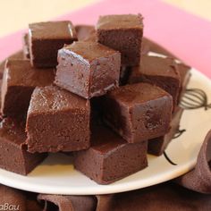 a white plate topped with brownies on top of a pink and yellow table cloth