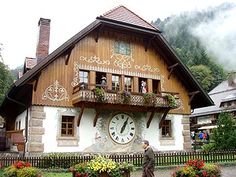 a man standing in front of a building with a clock on it