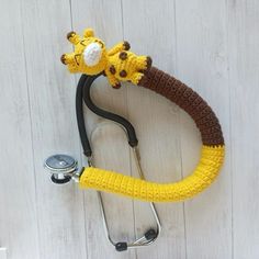 a crocheted giraffe stethoscope attached to a wall