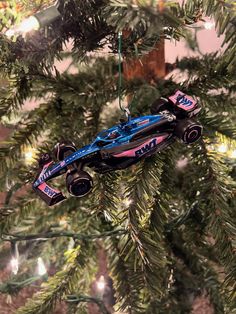 a blue race car ornament hanging from a christmas tree