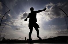 the silhouette of a man playing with a soccer ball