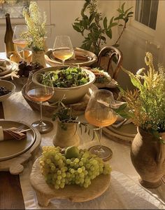 the table is set with plates, wine glasses and other items for dinner or brunch