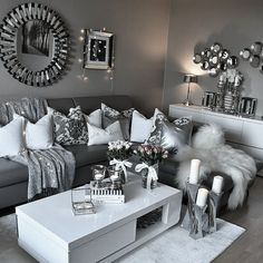 a living room filled with lots of furniture and mirrors on the wall above it's coffee table