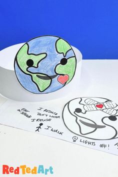 a paper plate with a drawing of the earth on it next to some stickers