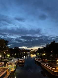 boats are lined up along the river at night