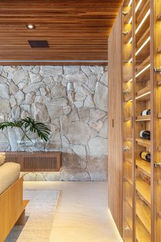 a living room filled with furniture and a stone wall