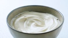 a bowl filled with white cream sitting on top of a table