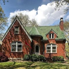 a red brick house with a green roof