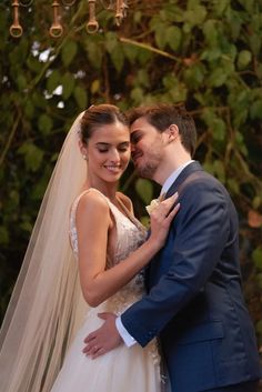 a bride and groom standing under a chandelier