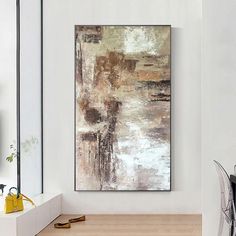 an abstract painting hangs on the wall in a white room with hardwood floors and large mirror