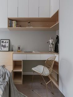 a bed room with a desk and a chair next to a book shelf filled with books