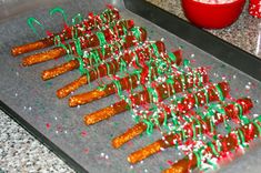 carrots are being cooked on a baking sheet with sprinkles and christmas decorations