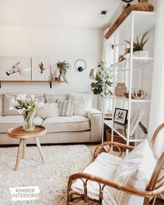 a living room filled with furniture and plants on top of a white carpeted floor