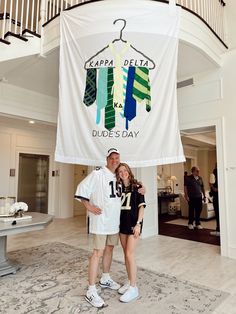 a man and woman standing in front of a sign that says kapa delta dude's day