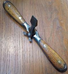 a wooden table with a knife on top of it and a hammer in the middle