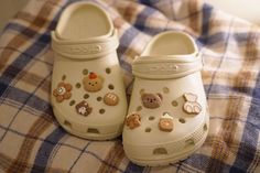 a pair of white shoes sitting on top of a bed covered in patches and buttons