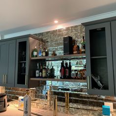 a kitchen with gray cabinets and marble counter tops