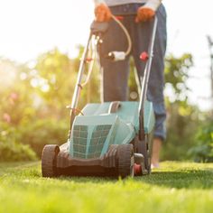 a man mowing the grass with a lawnmower