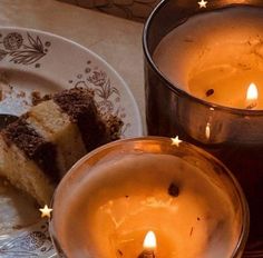 two candles sitting on top of a white plate