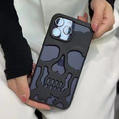 a person holding a cell phone case with a skull design on the front and sides