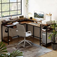 a home office with a desk, computer and plant in the corner by the window