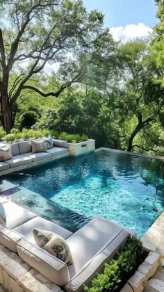 an outdoor living area with couches and a swimming pool in the middle of it