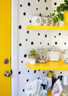 yellow shelves with black and white polka dot wallpaper