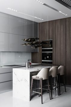 a modern kitchen with marble counter tops and stools