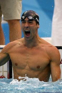 a shirtless man is in the water with his mouth open