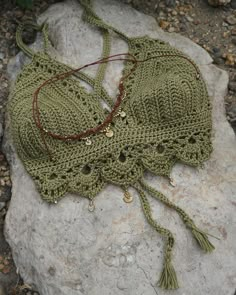 two crocheted hats sitting on top of a rock