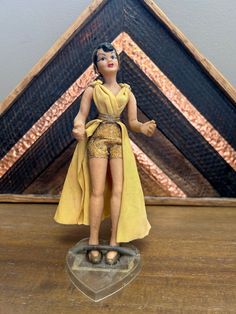 a figurine that is sitting on top of a wooden table in front of a triangle