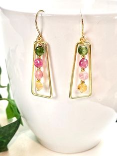 So pretty and cheerful, these earrings will bring you and those who look at you wearing them a smile to your faces! Clear and bright Tourmaline gemstones are in colors of pale yellow, pale pink, pink and grassy green. Each gem has a smooth, high polish. The gemstones dangle within a Vermeil gold frame and hang 1.75 inches on Vermeil gold ear wires. A wonderful gift for any occasion and arrives in a standard gift box. FOR GIFT GIVING: ** Satin gift pouch with a note card and upgraded box is also Multicolor Birthstone Earrings For Gift, Handmade Tourmaline Dangle Earrings, Green Tourmaline Earrings For Gift, Tourmaline Drop Earrings, Box For Gift, Tourmaline Earrings, Earrings Colorful, Tourmaline Jewelry, Colorful Jewelry