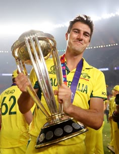 a man in yellow uniform holding up a trophy