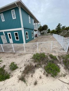 a house on the beach with a fence around it