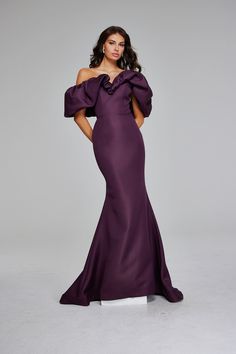 a woman in a purple dress posing for the camera with her hands on her hips